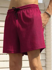 Burgundy drawstring chino shorts with textured fabric and pockets.