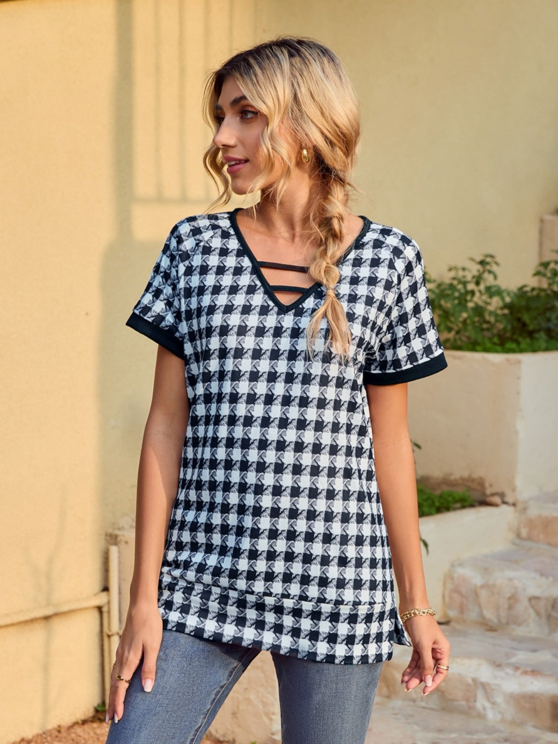 Houndstooth tunic top with cutout neckline and short sleeves.