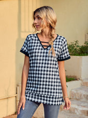 Houndstooth tunic top with cutout neckline and short sleeves.