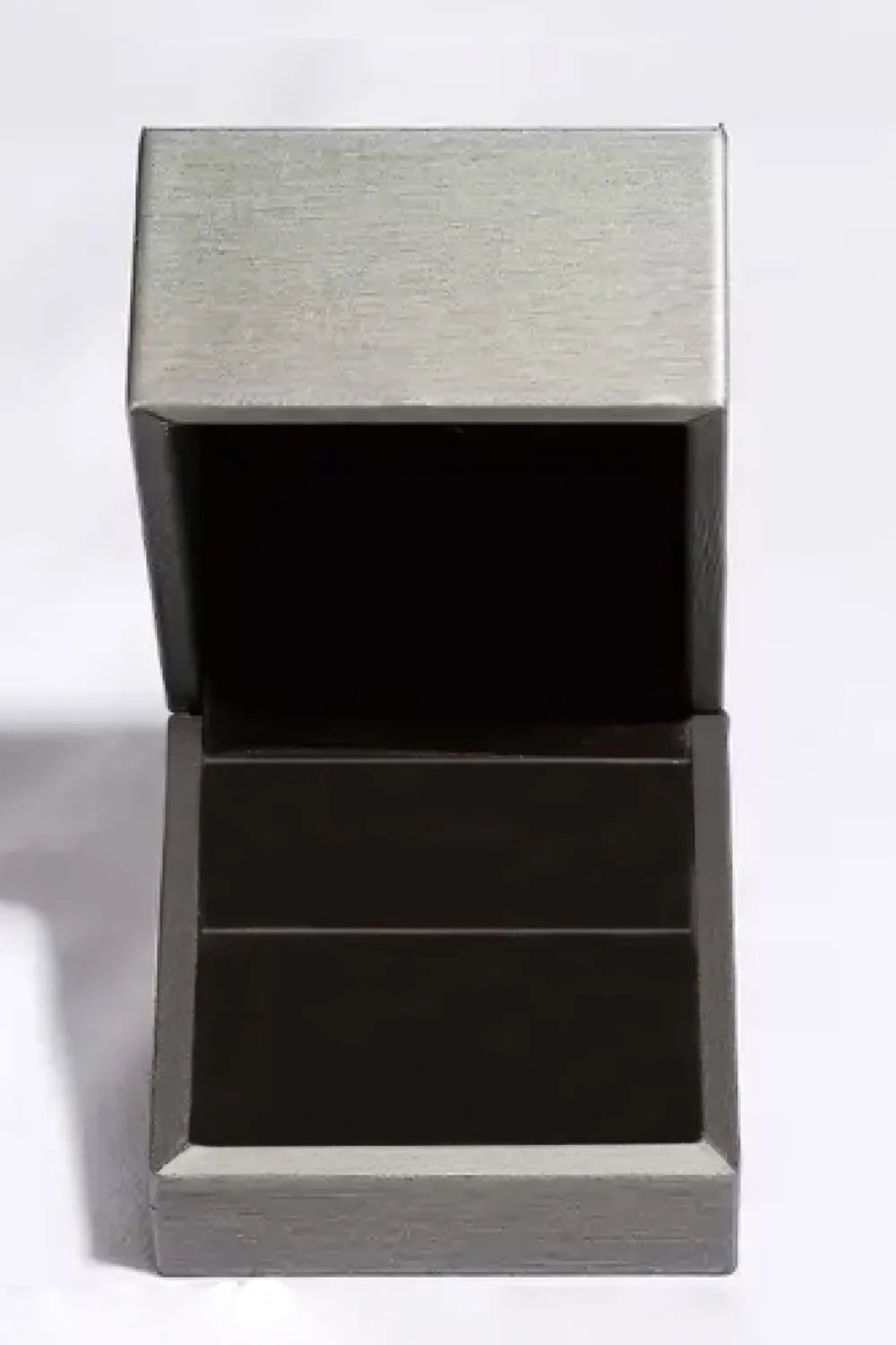 Silver ring box with open lid and dark interior