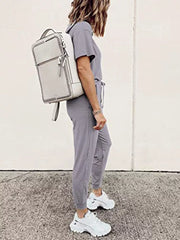 Grey casual round neck top and jogger pants set with drawstring waist, styled with white sneakers and backpack.