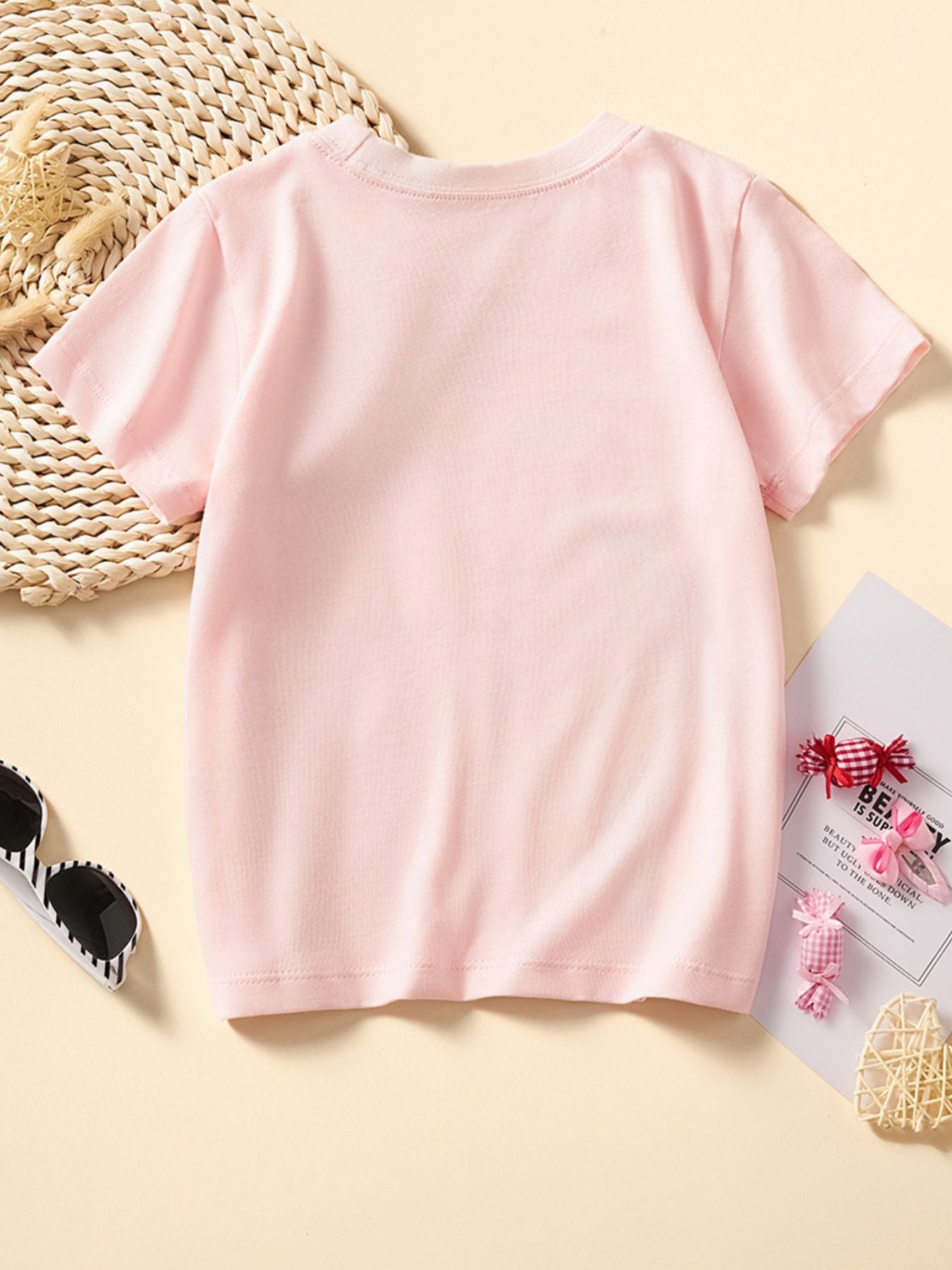 Toddler blush pink cotton crew neck t-shirt with a unicorn graphic.