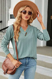 Textured cable-knit henley pullover in light blue with button detail and v-neck.