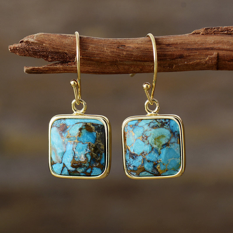 Turquoise matrix square drop earrings with gold-tone hooks.