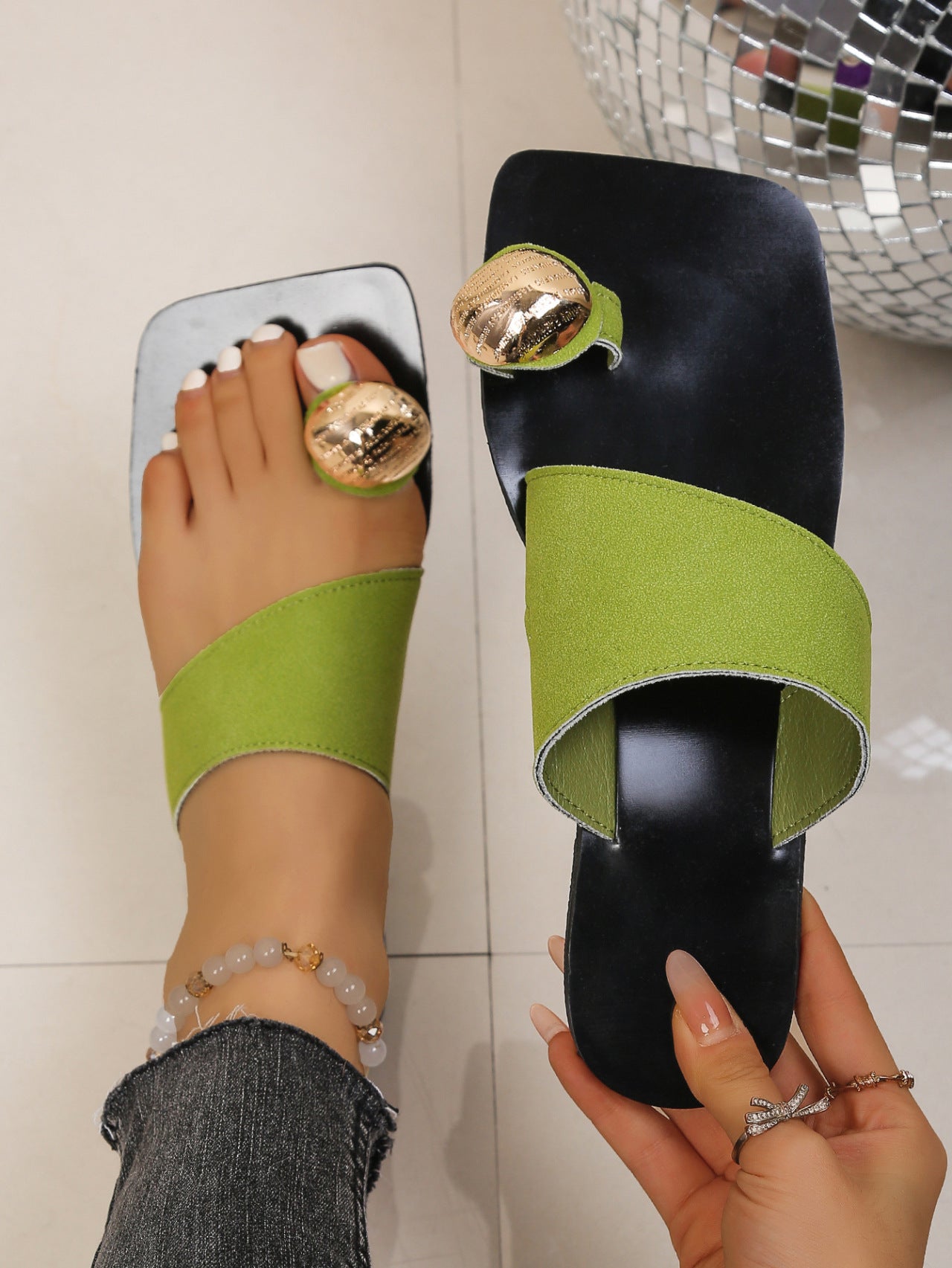 Chic square toe ring sandals in black with lime green asymmetric strap and gold accent.