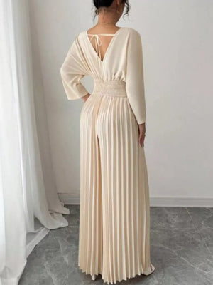 Beige pleated wide-leg jumpsuit with cinched waist and V-neck back tie detail