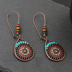 Bohemian mandala drop earrings in copper with turquoise and red accents.