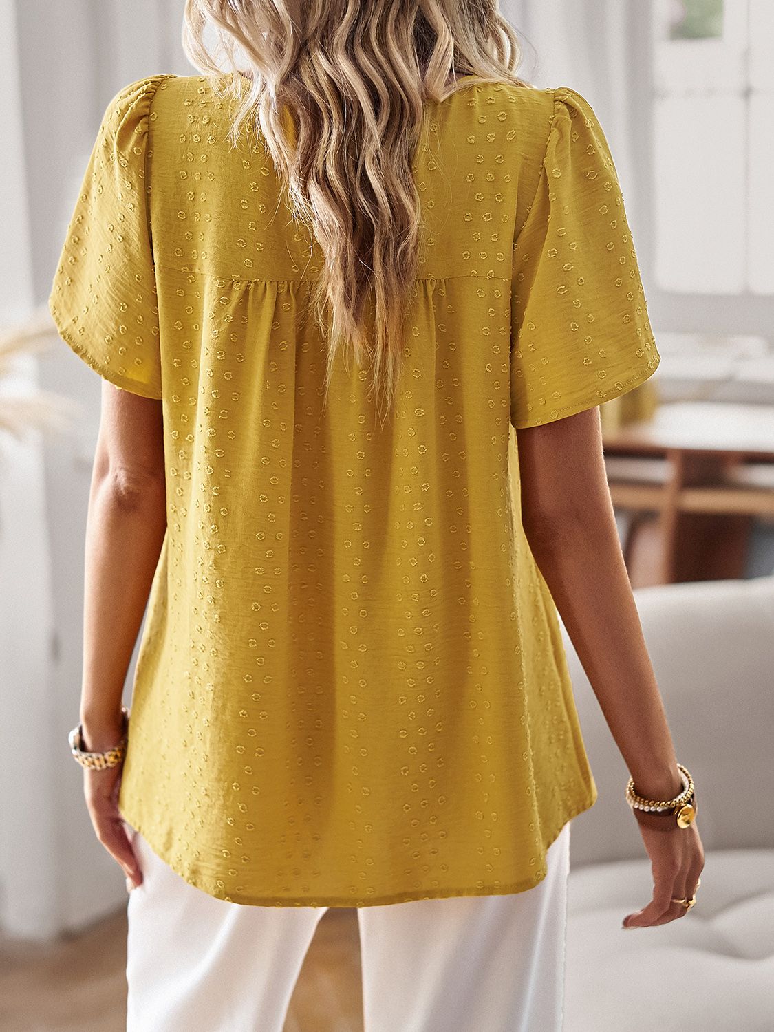 Yellow textured puff sleeve blouse with gathered yoke and short sleeves.