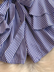 Blue and white striped romper with ruffles and a bow detail.