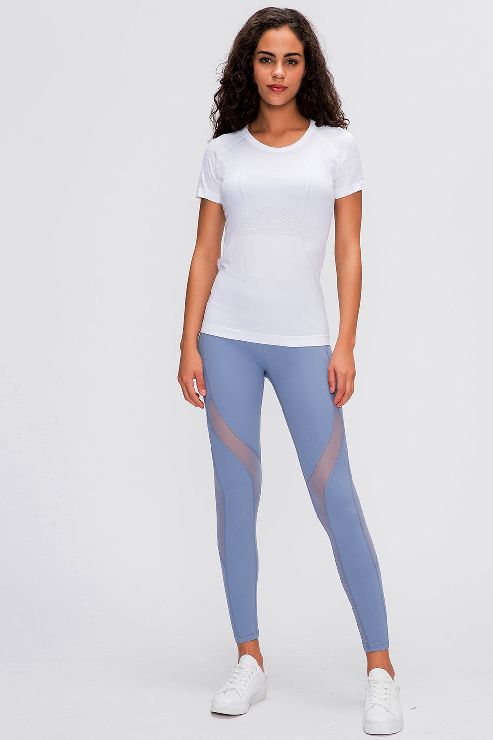 White seamless activewear tee with short sleeves and crew neck, paired with blue mesh panel leggings.