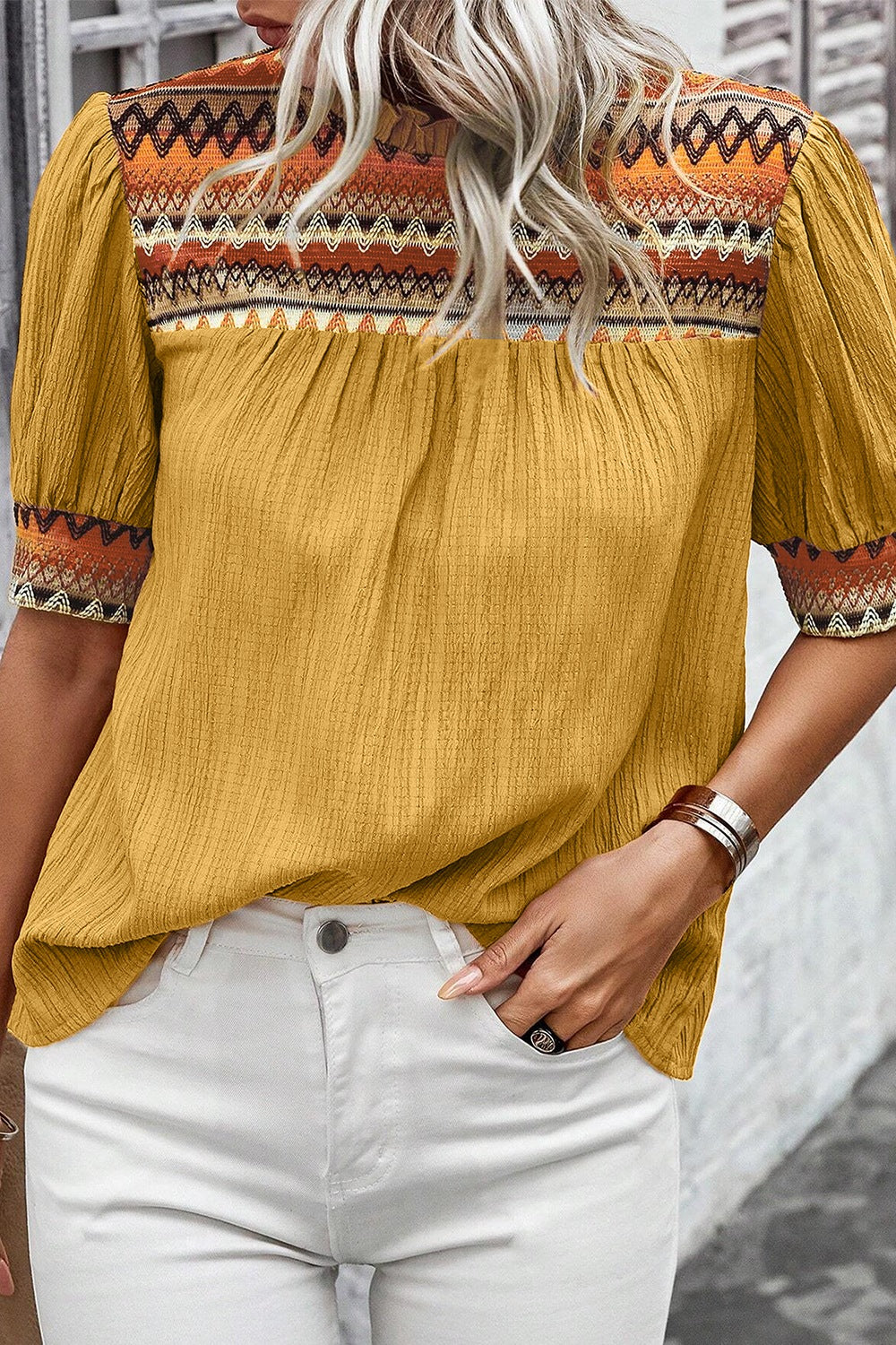 Mustard yellow blouse with embroidered yoke and puff sleeves.