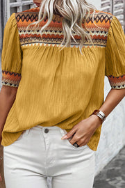 Mustard yellow blouse with embroidered yoke and puff sleeves.
