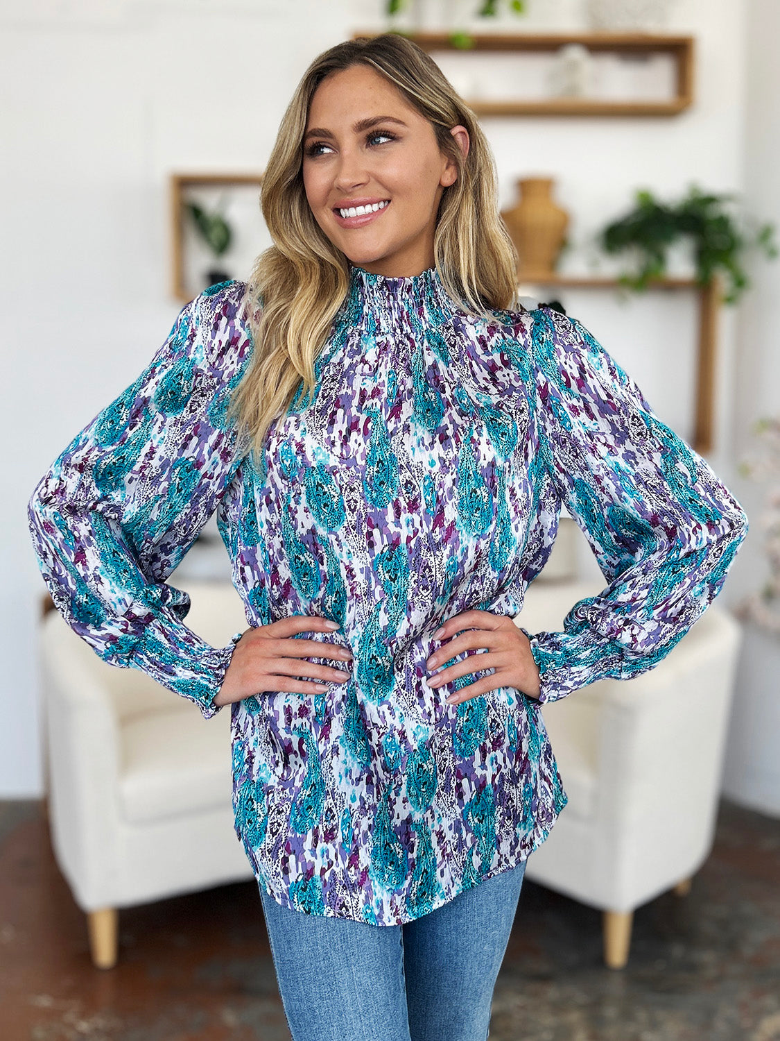 High neck abstract print blouse with smocked collar and cuffs in blue and violet tones.