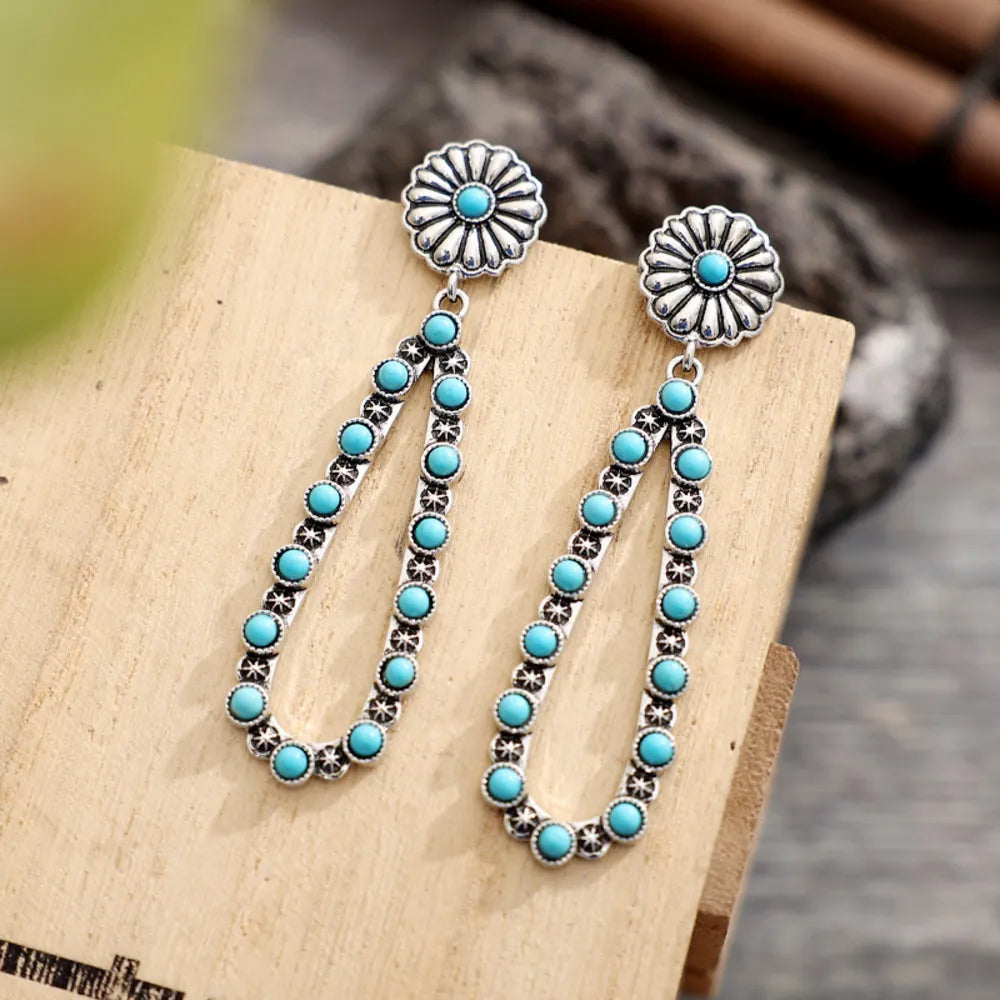 Silver floral turquoise bead drop earrings with a blossom pattern.