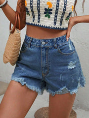 Distressed denim shorts in medium wash with frayed hem and button fly.
