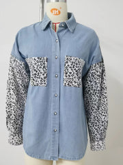 Denim shirt with leopard print sleeves and chest pockets. Button-up style.
