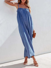 Gathered bodice denim jumpsuit in medium blue, with spaghetti straps and wide legs.