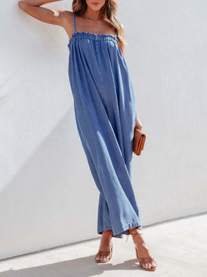 Gathered bodice denim jumpsuit in medium blue, with spaghetti straps and wide legs.
