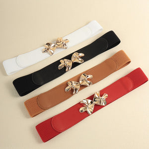 Elasticated waist belt in ivory, black, caramel, and brick red with gold bow clasp.