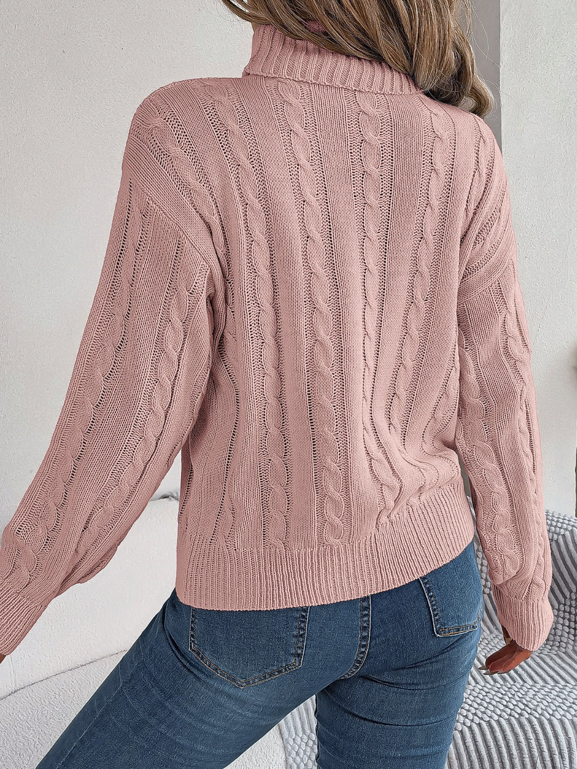 Dusty pink cable knit turtleneck sweater with voluminous sleeves and ribbed cuffs.