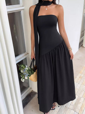 Black strapless maxi dress with asymmetrical ruffled hem and matching scarf detail.