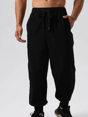Black relaxed fit joggers with adjustable drawstring waist and seam details.
