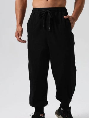 Black relaxed fit joggers with adjustable drawstring waist and seam details.
