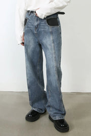 Panel seam denim trousers in medium wash with black pocket details and a relaxed fit.