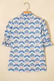Blouse with floral pattern, high neck, and ruffled cuffs.