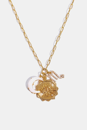 Gold celestial pendant necklace with moon, sun, and zodiac charm.