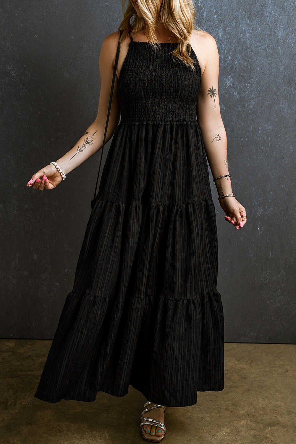 Black tiered maxi dress with a textured smocked bodice and square neckline.