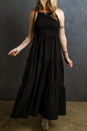 Black tiered maxi dress with a textured smocked bodice and square neckline.