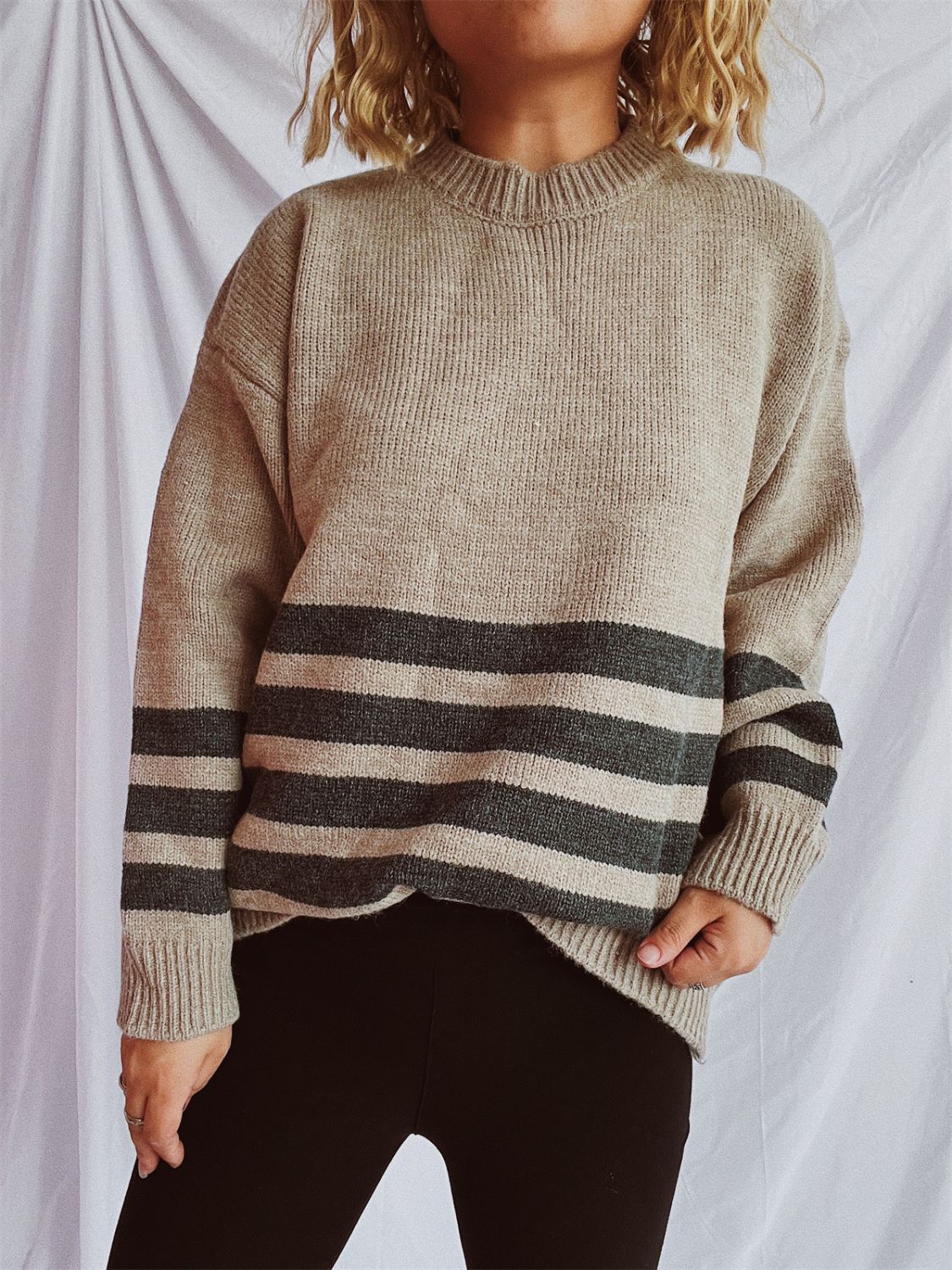 Tan ribbed knit sweater with horizontal dark gray stripes, crew neck, and long sleeves.