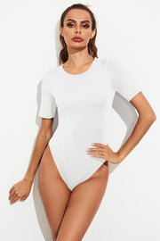 White crew-neck jersey bodysuit with short sleeves and a high-cut leg.