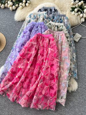 Layered floral embroidered midi skirt in pink, purple, gray, and apricot blue flower colors.