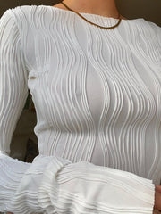 White textured fitted blouse with long sleeves and asymmetrical hem detail.