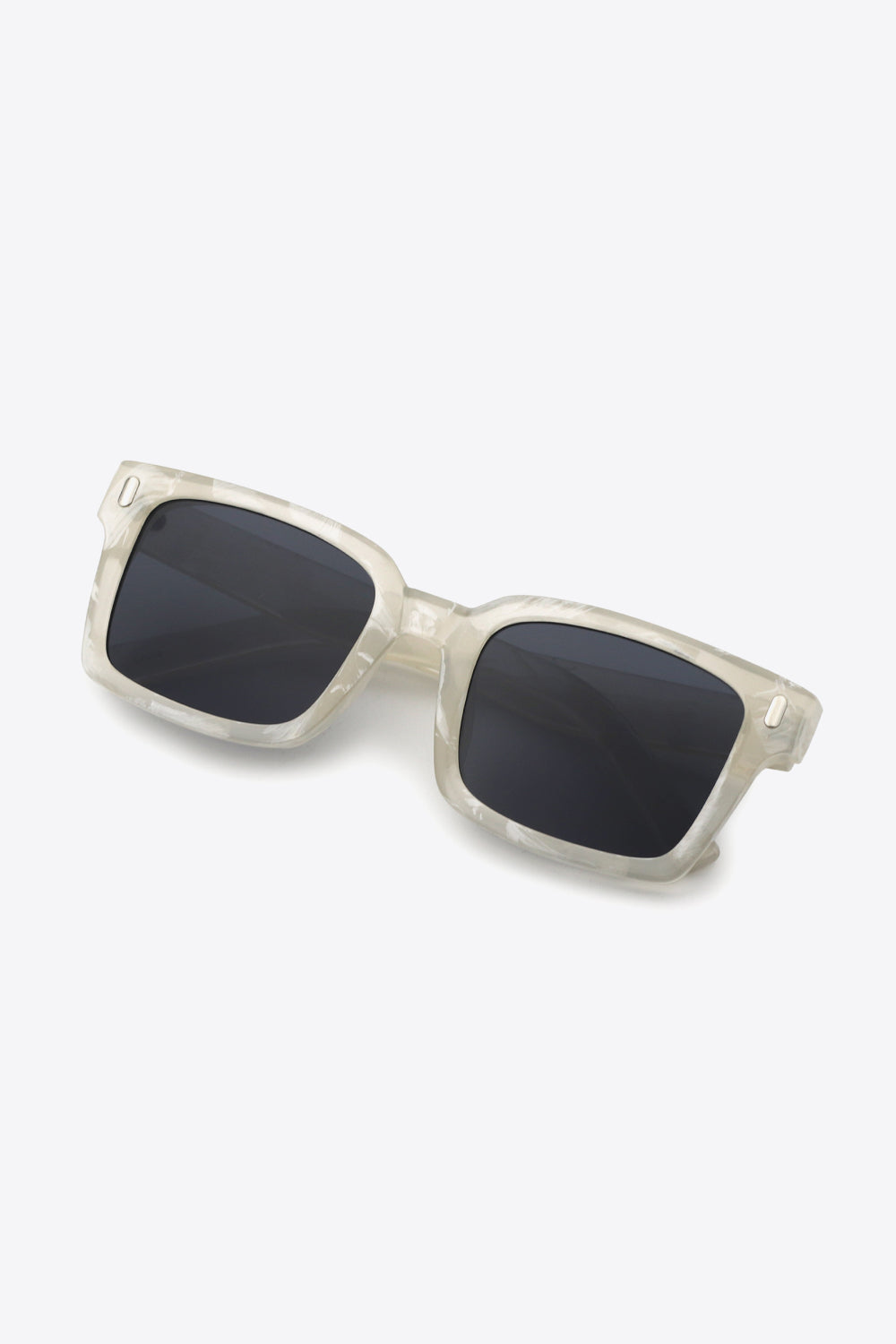 Marble effect rectangular sunglasses with dark lenses and a clear frame.
