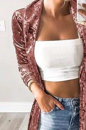 Crushed velvet duster coat in pale blush with long sleeves and an open front, styled casually.