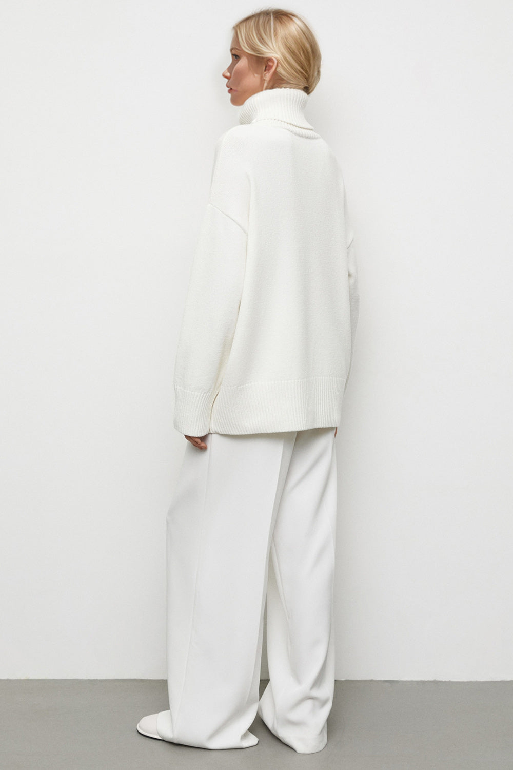 White oversized turtleneck knit sweater with a relaxed fit and dropped shoulders.