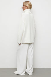 White oversized turtleneck knit sweater with a relaxed fit and dropped shoulders.