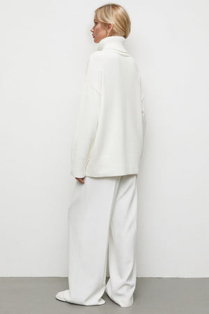 White oversized turtleneck knit sweater with a relaxed fit and dropped shoulders.