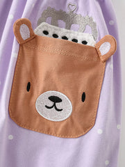 Lavender polka dot cotton dress with a brown bear applique pocket and crown detail.