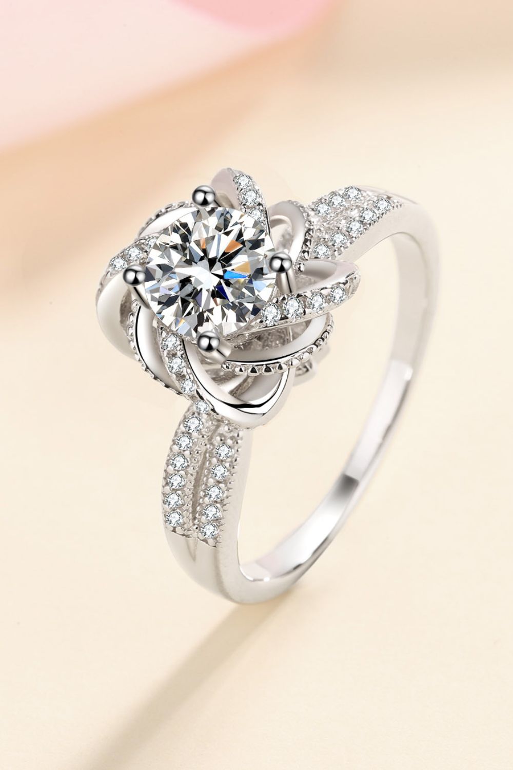 Silver floral halo ring with moissanite and pave accent stones.