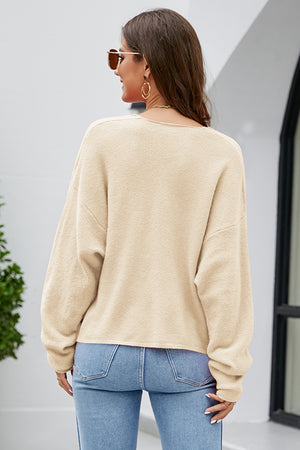 Caramel fluffy knit sweater with a plunging neckline and long sleeves.