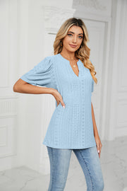Blue perforated puff sleeve blouse with keyhole neckline and eyelet detail.