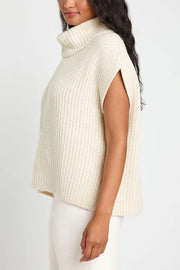 Sleeveless ribbed turtleneck sweater in ivory with side arm slits.