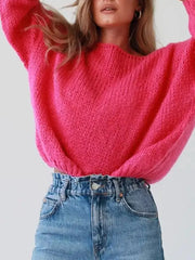 Hot pink chunky knit sweater with boat neck and oversized balloon sleeves, styled with denim.
