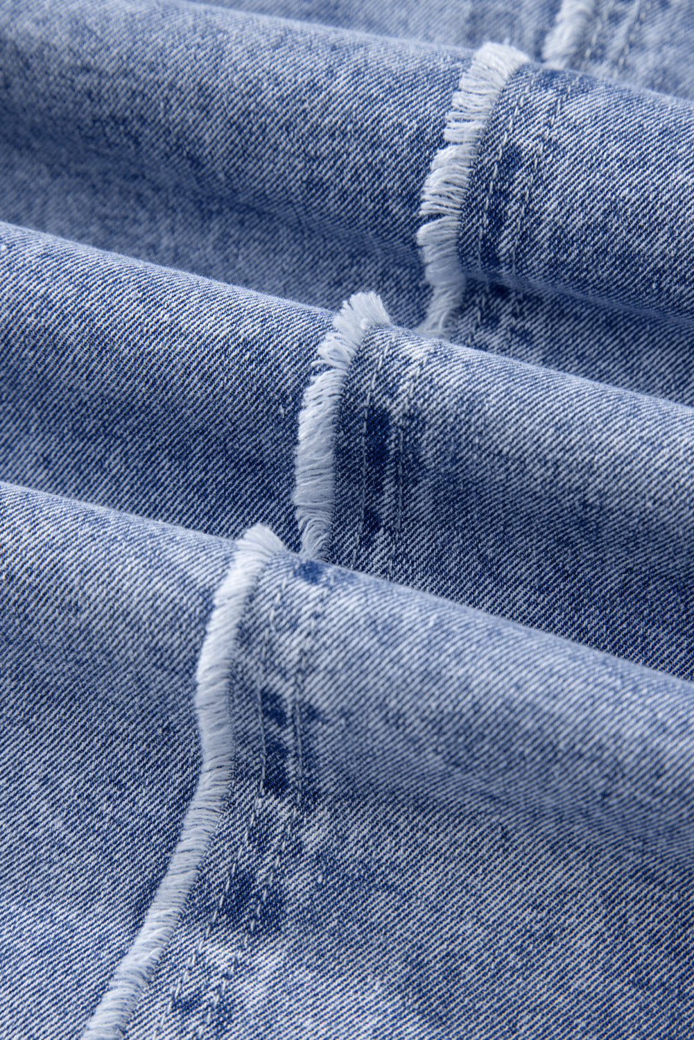 Acid wash denim shirtdress in medium blue with raw hem detail.