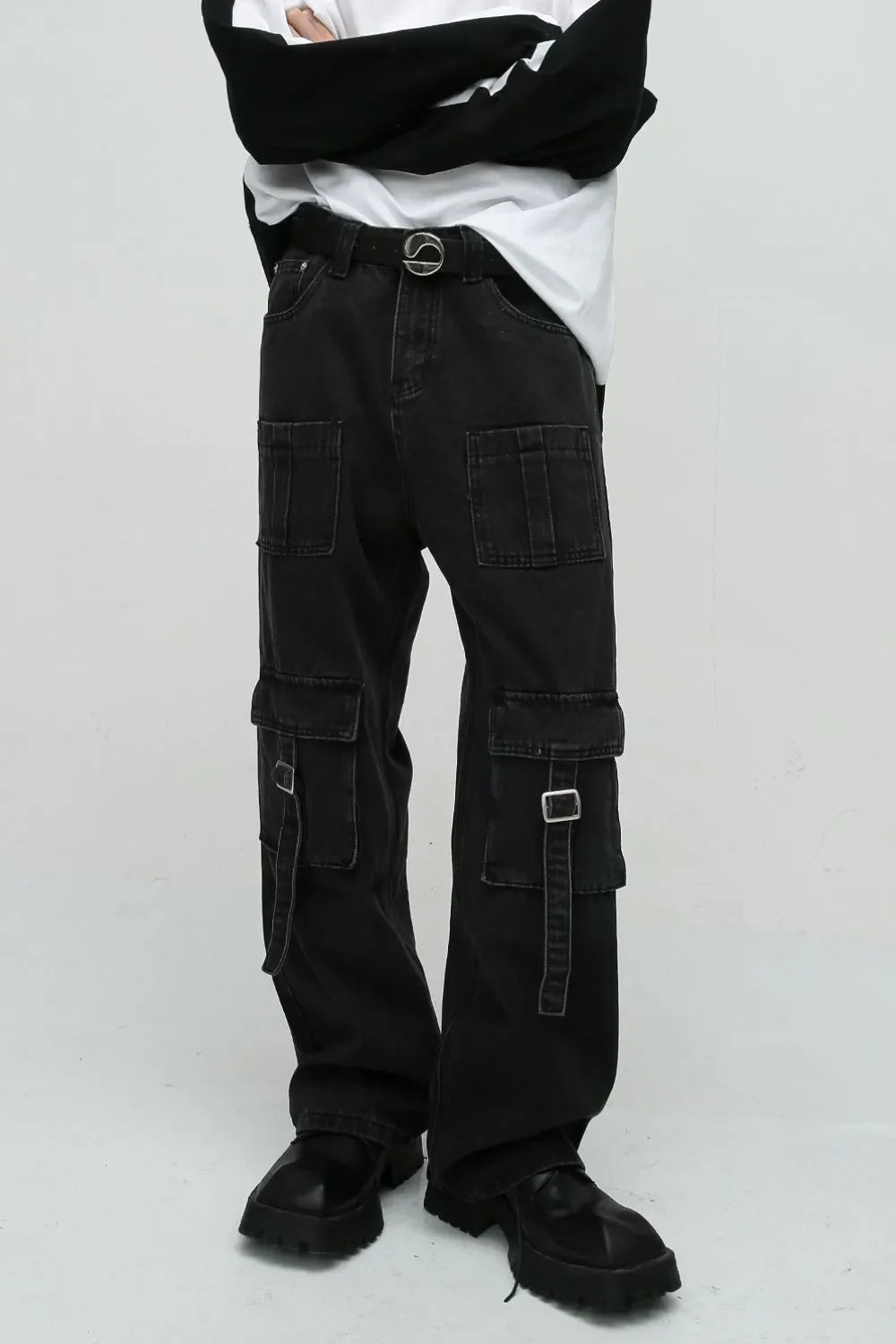 Dark utility denim cargo pants with buckle pockets and a statement belt.