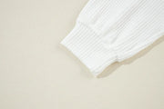 White ribbed knit sweatshirt cuff detail showing textured fabric and elasticized hem.